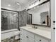Bathroom with grey stone shower, white vanity, and a bathtub at 879 Big Horn Hollow, Suwanee, GA 30024