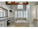 Elegant bathroom with a soaking tub, granite counters, and an abundance of natural light at 879 Big Horn Hollow, Suwanee, GA 30024