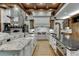 Open concept kitchen with double islands, stone fireplace, and wood beams at 879 Big Horn Hollow, Suwanee, GA 30024