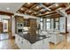 Spacious kitchen with large island, custom cabinetry, and wood beamed ceiling at 879 Big Horn Hollow, Suwanee, GA 30024