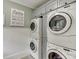 Well-organized laundry room with stacked washer and dryer units and overhead storage cabinets at 879 Big Horn Hollow, Suwanee, GA 30024