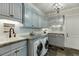 Bright laundry room with granite countertops and shaker cabinets at 879 Big Horn Hollow, Suwanee, GA 30024