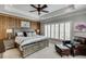 Spacious bedroom with wood-paneled accent wall and a sitting area at 879 Big Horn Hollow, Suwanee, GA 30024