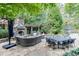 Luxurious outdoor living space with a stone fireplace, dining area, and comfortable seating at 879 Big Horn Hollow, Suwanee, GA 30024