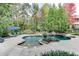 Stunning pool area surrounded by a manicured lawn, patio, and mature trees at 879 Big Horn Hollow, Suwanee, GA 30024