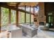 Spacious screened porch with stone flooring, fireplace, and comfortable seating at 879 Big Horn Hollow, Suwanee, GA 30024