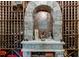 A well-stocked wine cellar featuring a stone arch and wooden shelving at 879 Big Horn Hollow, Suwanee, GA 30024