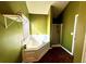 Bright bathroom featuring a soaking tub, glass shower, and warm green colored walls at 2717 Kristen Ct, Conyers, GA 30012