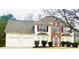 Two-story home with a two-car garage, red accents, brick and white siding, and an arched window at 2717 Kristen Ct, Conyers, GA 30012