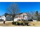 Two-story home with a long driveway, two-car garage, and a manicured front lawn under a clear blue sky at 2717 Kristen Ct, Conyers, GA 30012