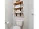 Neutral bathroom boasts sleek shelving, stacked white towels and toilet at 802 Oak Promenade Ln, Canton, GA 30115