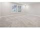 An empty bedroom with neutral walls and carpet and a large window at 802 Oak Promenade Ln, Canton, GA 30115