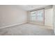 Neutral bedroom featuring plush carpeting, natural light, and a closet door at 802 Oak Promenade Ln, Canton, GA 30115