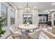 Bright dining room with a modern chandelier and natural light from large windows at 802 Oak Promenade Ln, Canton, GA 30115