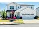 Charming two-story home with white siding, well-manicured lawn and beautiful, colorful flower beds at 802 Oak Promenade Ln, Canton, GA 30115