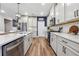 Modern kitchen featuring stainless steel appliances, ample white cabinetry, and hardwood floors at 802 Oak Promenade Ln, Canton, GA 30115