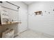 Well-organized laundry room with shiplap accent wall, mounted shelving, and charming laundry-themed decor at 802 Oak Promenade Ln, Canton, GA 30115