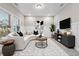 Inviting living room with a sectional sofa, decorative rug, and entertainment center at 802 Oak Promenade Ln, Canton, GA 30115