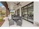 Covered patio featuring modern outdoor seating, ceiling fans, and expansive glass doors for seamless indoor-outdoor living at 802 Oak Promenade Ln, Canton, GA 30115