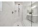 Glass enclosed shower with large rain head and white tile with gray veining, in modern en suite bathroom at 802 Oak Promenade Ln, Canton, GA 30115
