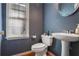 Stylish powder room with pedestal sink and hardwood floor at 3559 Gus Way, Powder Springs, GA 30127