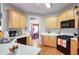 Kitchen features light wood cabinets, black appliances, and white countertops at 3559 Gus Way, Powder Springs, GA 30127