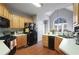 Kitchen boasts light wood cabinets, black appliances, and an arched window at 3559 Gus Way, Powder Springs, GA 30127