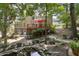 An expansive backyard view showcases a lush landscape, complemented by a tranquil pond and outdoor deck at 1400 Lamont Cir, Dacula, GA 30019