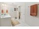 Bright bathroom with white tiled floors, double sinks, and a view into the toilet area at 1400 Lamont Cir, Dacula, GA 30019