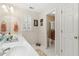 Bright bathroom with white tiled floors, double sinks, and a view into the shower at 1400 Lamont Cir, Dacula, GA 30019
