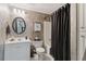 Cozy bathroom featuring a shower-tub combo with a dark shower curtain, decorative walls, and vanity sink at 1400 Lamont Cir, Dacula, GA 30019