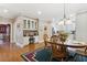 Open-concept dining area boasts built-in desk and cabinets, chandelier, and hardwood floors at 1400 Lamont Cir, Dacula, GA 30019