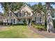 This stately home features a lush front lawn, mature trees, and a classic facade with elegant details at 1400 Lamont Cir, Dacula, GA 30019