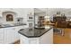 Open kitchen with dark granite countertops, white cabinets, and an eat-in island at 1400 Lamont Cir, Dacula, GA 30019