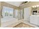 A spacious main bathroom with a separate tub, shower, and a large window providing natural light at 1400 Lamont Cir, Dacula, GA 30019