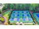 Aerial view of community tennis courts with shade umbrellas and nearby trees at 1400 Lamont Cir, Dacula, GA 30019