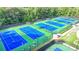 Aerial view of community tennis courts with green and blue surface, with trees in the background at 1400 Lamont Cir, Dacula, GA 30019