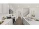 Bright kitchen with white cabinets, stainless steel appliances, breakfast bar, and hardwood floors at 584 Silver Moon Dr, Loganville, GA 30052