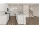 An open-concept kitchen features an island with sink, white cabinets, and stainless steel appliances at 345 Sound Cir # 134, Stockbridge, GA 30281