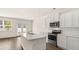 Bright kitchen boasts white cabinetry, stainless steel appliances, and an island with a double sink at 345 Sound Cir # 134, Stockbridge, GA 30281