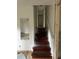 View of a wooden stairway featuring a reflective mirror leading to the upstairs hall at 3230 Vanderbilt Nw Ln, Atlanta, GA 30318