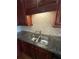 View of the kitchen sink and granite countertops with cherry cabinets at 2300 Peachford Rd # 1209, Atlanta, GA 30338