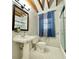 Bathroom featuring a pedestal sink, exposed beams, and ample natural light at 589 Northern Ave, Clarkston, GA 30021