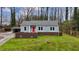Charming blue home with red door, brick accents, and a well-maintained lawn at 589 Northern Ave, Clarkston, GA 30021