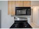 Modern kitchen featuring a black stove, stainless steel appliances and wood cabinets at 589 Northern Ave, Clarkston, GA 30021