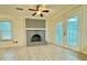 Bright living room with a painted brick fireplace, ceiling fan, and view to the outdoor patio at 589 Northern Ave, Clarkston, GA 30021