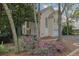 Beige two-story house with blooming azaleas and a paved driveway at 10 Braemore Dr, Sandy Springs, GA 30328