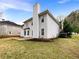 Backyard view of home featuring spacious lawn, concrete patio and tall chimney at 1615 Cheshire Ct, Lawrenceville, GA 30043