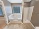 Bathroom featuring a shower, tub, and large window with natural light at 1615 Cheshire Ct, Lawrenceville, GA 30043