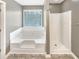 Bright bathroom featuring a large tub with white tile surround and a separate shower at 1615 Cheshire Ct, Lawrenceville, GA 30043